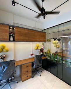 Home office with wood shelving, twin desks, and a glass partition